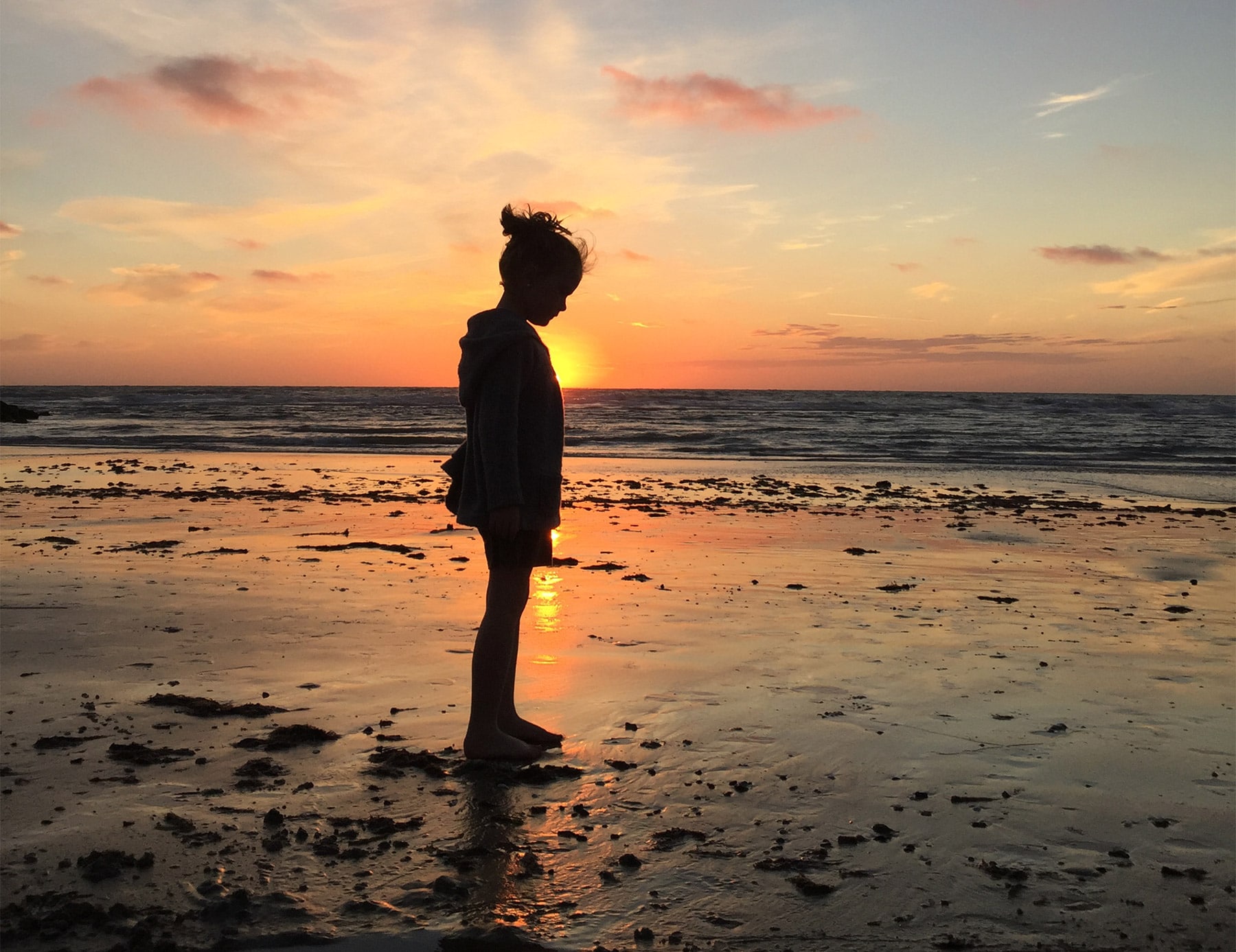 Jente i solnedgang på stranden